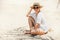 Happy smiling sunbathing woman in straw hat portrait. Palm tree shadows on the sand. Healthy tanning and vacation concept image