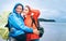 Happy smiling travelers couple in rainy day on the ocean beach