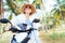 Happy smiling traveller woman riding motorbike under palm trees