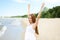 Happy smiling woman in free happiness bliss on ocean beach standing with raising hands. Portrait of a multicultural