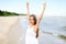 Happy smiling woman in free happiness bliss on ocean beach standing with raising hands. Portrait of a multicultural