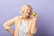 Happy smiling woman in her sixties holding green apple and smiling at camera.