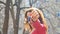 Happy smiling woman holding her new apartment or car keys in one hand with red manicure outdoors during spring time on