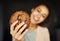 Happy smiling woman holding huge chocolate cookie, focus on cookie
