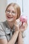 Happy smiling woman holding piggy bank.