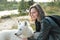 happy smiling woman hugging her dog on a river bank. yakutian laika looking aside. animal friends, outdoor activity and