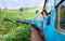 Happy smiling woman looks out from window traveling by train on