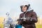 Happy and smiling woman motorcyclist get ready to steering chopper in leather jacket and white safety helmet, outdoors