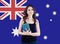 Happy smiling woman student with book against australian flag background. Travel and education in Australia