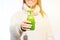 Happy smiling woman in woollen sweater holding bottle with green homemade peppermint mocha milkshake