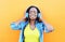 Happy smiling young african woman with headphones enjoying listens to music