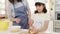 Happy smiling young Asian Japanese family with preschool kids have fun cooking baking pastry or pie for breakfast meal in modern