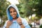 Happy smiling young beautiful hispanic woman with brown eyes looking at the camera. Girl wearing blue fashionable hoodie and a lot