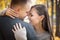 Happy smiling young Central Asian woman hugging her caucasian husband on a date in a autumn outdoor