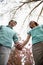 Happy smiling young couple holding hands in the park in springtime, low angle view