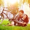 Happy smiling young couple lying in a park near a vintage bike