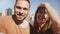 Happy smiling young newlyweds waving to camera on online video chat with friends at New York skyline view of Manhattan.