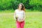 Happy smiling young pregnant woman with flowers outdoors