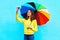Happy smiling young woman with autumn colorful umbrella taking photo makes self portrait on smartphone over colorful blue