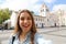 Happy smiling young woman in Sao Paulo city center take self portrait with Patio do Colegio landmark on the background, Sao Paulo