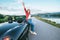 Happy smiling young woman stay near the cabriolet car on the mountain road