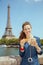 Happy solo traveller woman with cup of coffee and croissant