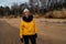 Happy sport and fashion lover enthusiast working out on a beach wearing bright yellow sweater and black gloves and a cap