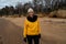 Happy sport and fashion lover enthusiast working out on a beach wearing bright yellow sweater and black gloves and a cap