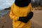 Happy sport and fashion lover enthusiast working out on a beach wearing bright yellow sweater and black gloves and a cap