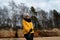 Happy sport and fashion lover enthusiast working out on a beach wearing bright yellow sweater and black gloves and a cap