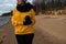 Happy sport and fashion lover enthusiast working out on a beach wearing bright yellow sweater and black gloves and a cap