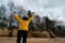 Happy sport and fashion lover enthusiast working out on a beach wearing bright yellow sweater and black gloves and a cap