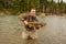 A happy sport fisherman proudly holding up his catch of a Chum Salmon