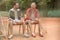 happy sportive friends with wooden rackets sitting on chairs