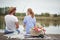 Happy spouses enjoy fishing and a picnic with their dog