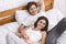 Happy spouses relaxing in bed and enjoying closeness