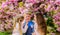 Happy spring vacation. Lost in blossom. Girls and boy friends posing near sakura. Kids on pink flowers of sakura tree