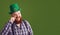 Happy St. Patricks Day. Fat funny man in a green hat smiles on a green background Patricks Day.