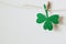 Happy St. Patricks day. Green glitter shamrocks decoration. Shiny paper cut clover leaf on clothespin