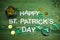 Happy St Patricks Day letters on green wooden background