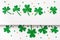 Happy St. Patricks Day minimal background. Green glitter shamrocks border on white background