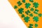 Happy St. Patrickâ€™s Day. Green hat and shamrock pattern on white and orange background.