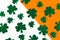 Happy St. Patrickâ€™s Day. Shamrock pattern on white and orange background.