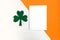 Happy St. Patrickâ€™s Day. Three leaf clover and white mockup blank on white and orange background. Patrick Day symbols on Ireland