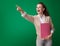 Happy student woman with pink notebook pointing at something