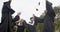 Happy  students in graduation gowns holding diplomas on university campus