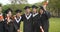 Happy  students in graduation gowns holding diplomas on university campus