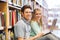 Happy students with laptop in library