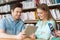 Happy students with tablet pc in library