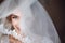 Happy stylish bride smiling and looking under veil. space for text. gorgeous emotional bride getting ready and having fun in the